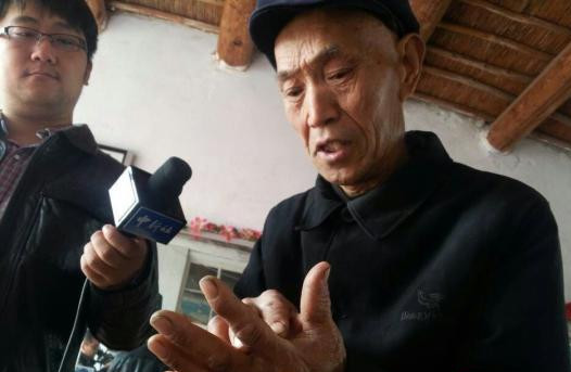 李太明老人正在向人们展示“一掌金”的计算方法