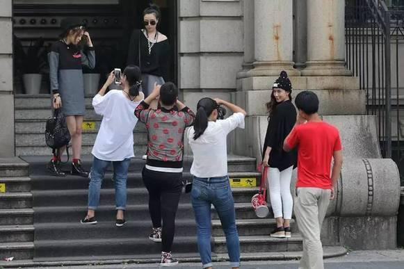 淘宝女模当街脱衣称一天拍200套时间紧 市民批不雅